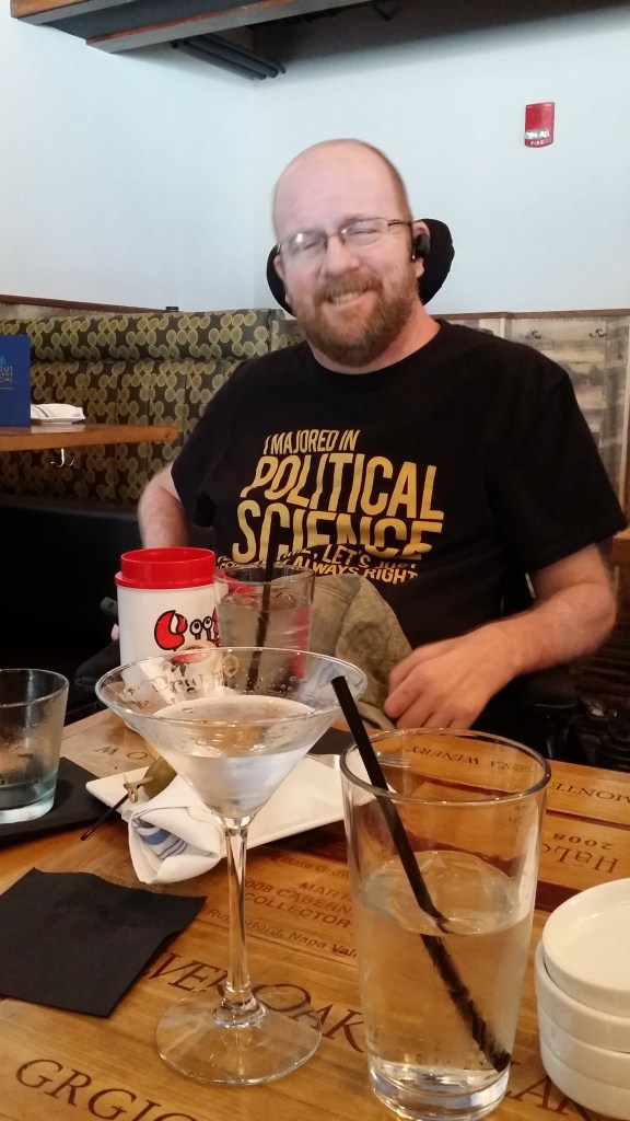 Kevin in a t-shirt reading, "I majored in Political Science. To save time, let's assume I'm always right." Martini and other glasses in the foreground.